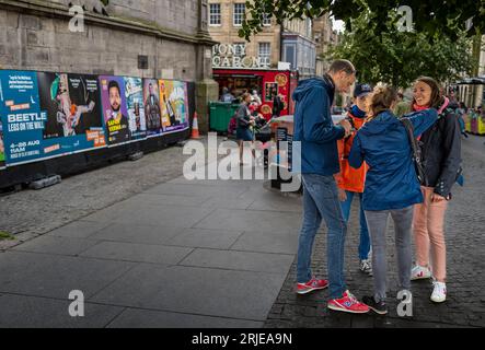 Une scène dans le Royal Mile d’Édimbourg pendant la dernière semaine du Festival Fringe 2023 d’Édimbourg. Amis se rencontrant dans la rue. Banque D'Images
