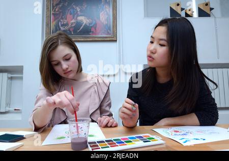 Deux adolescentes peignant le motif national tartare de Crimée ornek sur un papier. 11 novembre 2021. Kiev, Ukraine Banque D'Images