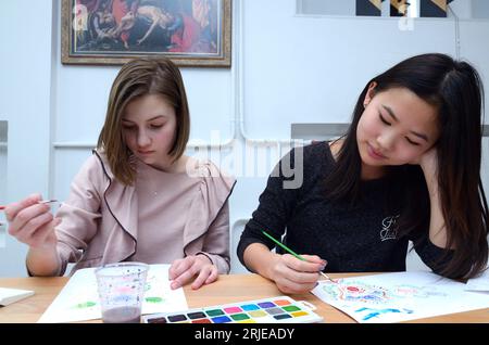 Deux adolescentes peignant le motif national tartare de Crimée ornek sur un papier. 11 novembre 2021. Kiev, Ukraine Banque D'Images