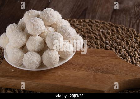 photo dessert sucré boules de noix de coco couchées sur une assiette et une planche de bois Banque D'Images