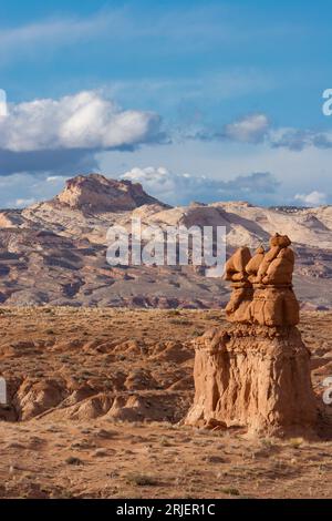 The Three Sisters or Three Kings, une formation rocheuse de grès d'Entrada dans le parc d'État de Gobllin Valley, Utah, avec le récif de San Rafael derrière. Banque D'Images