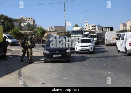 Hébron. 22 août 2023. Des véhicules palestiniens font la queue à un point de contrôle près de la ville de Hébron en Cisjordanie, le 22 août 2023. Une femme israélienne a été tuée et un homme a été grièvement blessé lundi par un tireur palestinien dans une attaque en voiture en Cisjordanie occupée, selon l’armée israélienne. Crédit : Mamoun Wazwaz/Xinhua/Alamy Live News Banque D'Images