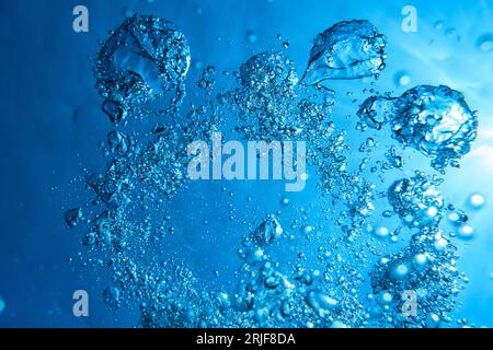 Fond plein cadre de figures abstraites faites par beaucoup de bulles d'air dans l'eau bleu foncé Banque D'Images