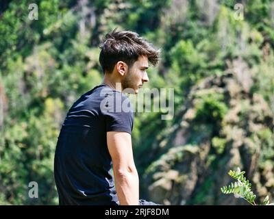 Photo d'un homme assis sur un rocher, contemplant la vue Banque D'Images