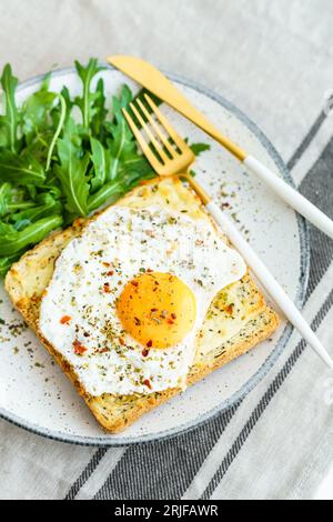 Délicieux petit déjeuner composé d'œufs frits, de pain grillé et de salade. Banque D'Images