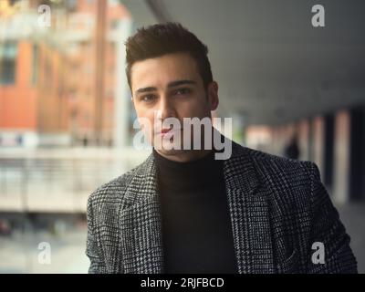 Photo d'un homme élégant portant un costume et un pull à col roulé Banque D'Images