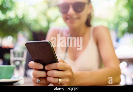Dispositif d'information portable dans les mains féminines gros plan avec mise au point sélective, en utilisant un téléphone intelligent, un accès wi-fi, la portabilité. Banque D'Images