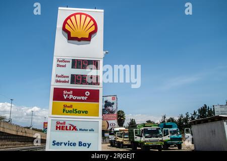 Nakuru, Kenya. 22 août 2023. Des camions sont vus emballés derrière un tableau affichant les prix des carburants dans une station Shell à Nakuru. Selon une analyse de Global Witness d’ici 2050, cinq grandes sociétés de combustibles fossiles – Shell, BP, ExxonMobil, Chevron et TotalEnergies – devraient utiliser un huitième du budget carbone mondial, mettant ainsi en péril l’objectif de 1,5°C de l’Accord de Paris. Crédit : SOPA Images Limited/Alamy Live News Banque D'Images