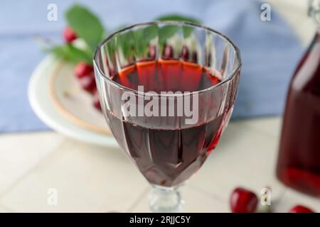 Verre de liqueur de cerise douce avec des baies dans la cuisine Banque D'Images