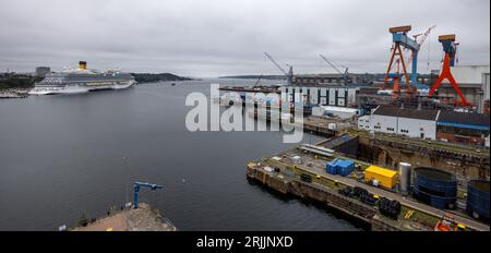 Kiel, Allemagne. 18 août 2023. Les nuages de pluie dérivent sur le chantier naval de ThyssenKrupp Marine Systems GmbH. La société a achevé une nouvelle salle ultramoderne pour la production de sous-marins. (À dpa 'Construction de sous-marins à TKMS plus rapide et plus efficace dans le nouveau hall ') crédit : Axel Heimken/dpa/Alamy Live News Banque D'Images