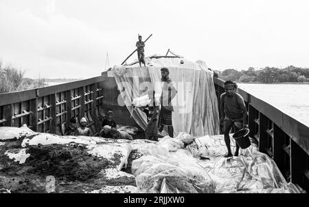 Les coques de bois sont déchargées du bateau. Cette photo a été prise le 14 septembre 2022 à Ruhitpur, Bangladesh Banque D'Images