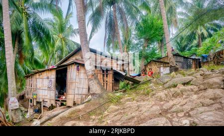 Île de Mindoro, Philippines - 15 avril 2023. Huttes de squatter simples faites à la main en bambou, bâches et toits en métal construits sur une colline à côté. Banque D'Images