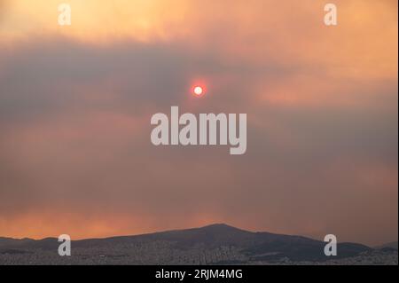 Le 22/08/2023 un feu de forêt a commencé sur les contreforts de la montagne Parnitha dans la banlieue ouest d'Athènes, Grèce. Alimentée par des vents violents, elle a rapidement grandi et brûlé des maisons et des commerces. Cette photo est de Lycabette colline dans le centre d'Athènes regardant vers la montagne. Banque D'Images