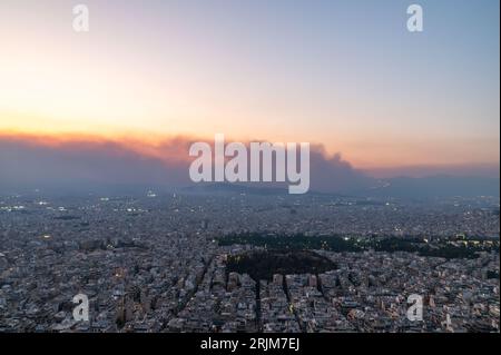 Le 22/08/2023 un feu de forêt a commencé sur les contreforts de la montagne Parnitha dans la banlieue ouest d'Athènes, Grèce. Alimentée par des vents violents, elle a rapidement grandi et brûlé des maisons et des commerces. Cette photo est de Lycabette colline dans le centre d'Athènes regardant vers la montagne. Banque D'Images