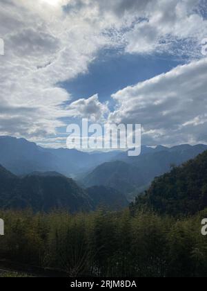 Une montagne majestueuse est exposée avec un ciel bleu sans nuages et de l'herbe verte luxuriante au premier plan Banque D'Images