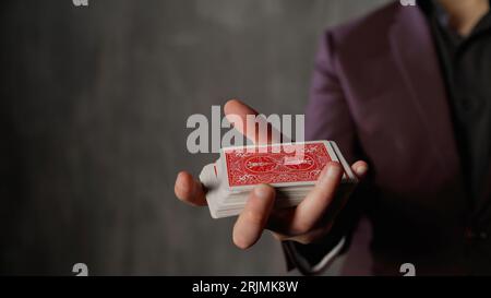 Magicien de cartes, croupier dans un casino montre en douceur un jeu de cartes. Jeu de tours de cartes. Concentrez-vous sur un jeu de cartes à jouer en gros plan. Banque D'Images