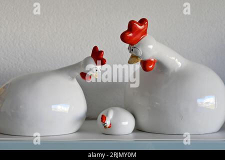 Famille céramique. Le coq père et la mère poule gardent un œil attentif sur leur poussin avec un regard inquiet Banque D'Images