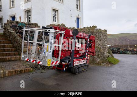 A tracked cherry picker parked on the slipway at St Abbs Banque D'Images