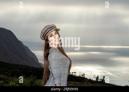 Élégance urbaine : une jeune Brunette confiante arborant un style audacieux avec une casquette chic à carreaux Banque D'Images
