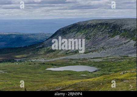 Majestueuse montagne Molnet Nipfjallet avec falaise rocheuse raide grise dans une vallée verdoyante et près d'un lac dans la nature sauvage suédoise. Banque D'Images