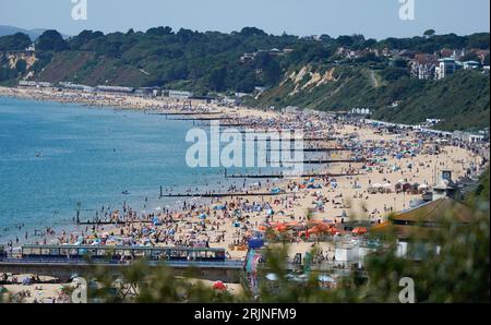 Les gens apprécient le temps chaud sur la plage de Bournemouth dans le Dorset. Une vague de chaleur mise en place pour balayer le pays mercredi pourrait être la dernière cette année, ont dit les prévisionnistes. Le met Office s'attend à ce que les températures atteignent un pic à la fin des années 20 dans certaines zones avant que les chutes de mercure et le soleil ne laissent place à des conditions plus instables pendant le jour férié.Date de la photo : mercredi 23 août 2023. Banque D'Images