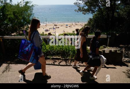 Les gens descendent vers la plage de Bournemouth dans le Dorset. Une vague de chaleur mise en place pour balayer le pays mercredi pourrait être la dernière cette année, ont dit les prévisionnistes. Le met Office s'attend à ce que les températures atteignent un pic à la fin des années 20 dans certaines zones avant que les chutes de mercure et le soleil ne laissent place à des conditions plus instables pendant le jour férié.Date de la photo : mercredi 23 août 2023. Banque D'Images