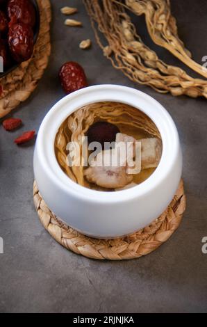 Un bol blanc rempli d'une gamme appétissante d'ingrédients colorés, y compris des dés de légumes et d'herbes, assis sur une table en bois Banque D'Images