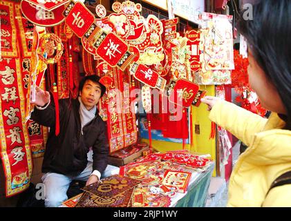 Bildnummer : 51058479 Datum : 10.01.2006 Copyright : imago/Xinhua Kundin und Marktverkäufer am Stand für Dekorationen auf einem Markt in Fuzhou - PUBLICATIONxNOTxINxCHN, Personen ; 2006, Fuzhou, Fujian, Markt, Märkte, Marktstand, Marktstände, Stand, Stände, Deko, DEKOS, Dekoration, Dekorationen, Verkäufer, Kunde, Kunden, Schriftzeichen, Schriftzug, chinesischer, chinesische, chinesisch ; , quer, Kbdig, Gruppenbild, Einzelhandel, Wirtschaft, Chine, Arbeitswelten, Gesellschaft, , / Frühlingsfest Banque D'Images