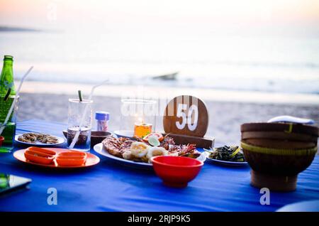 Dîner de fruits de mer avec vue sur le coucher du soleil à Jimbaran Beach, Bali Banque D'Images