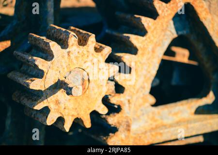 Gros plan d'engrenages métalliques anciens et rouillés d'une locomotive à vapeur, utilisés pour entraîner une machine à eau Banque D'Images