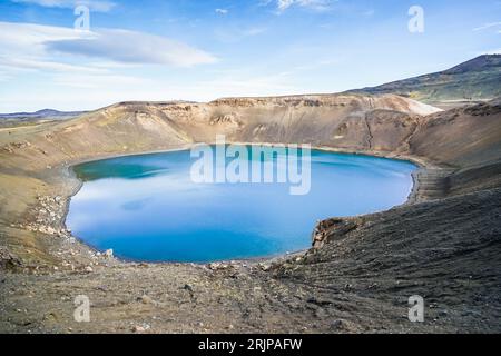 Une vue aérienne imprenable sur un cratère isolé dans un paysage sauvage, baigné de soleil et entouré de collines Banque D'Images