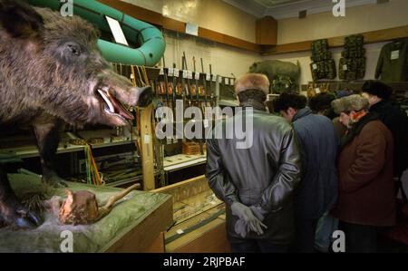 Volgograd, Russie - janvier 1996 : image de film numérisée, chasseurs sportifs russes magasinant des armes à feu et des fournitures de chasse. Sanglier à proximité. Éditorial Banque D'Images