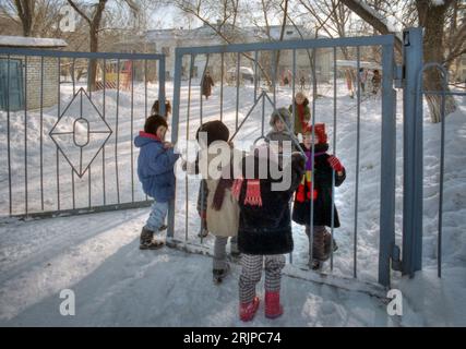 Volgograd, Russia - January 1996: Scanned film image of Russian school children walking to school in the snow. Editorial. Stock Photo