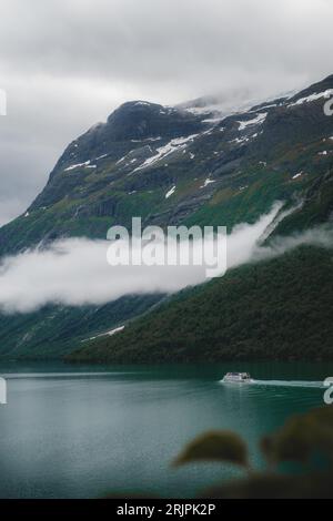 Un lac tranquille entouré de forêts verdoyantes et de majestueuses montagnes enneigées, créant un paysage à couper le souffle Banque D'Images