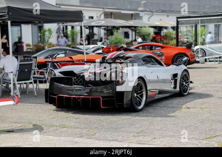 Une Pagani Huayra Roadster BC 1,20 brillante stationnée sur une surface pavée avec des jantes en alliage rouge vif Banque D'Images