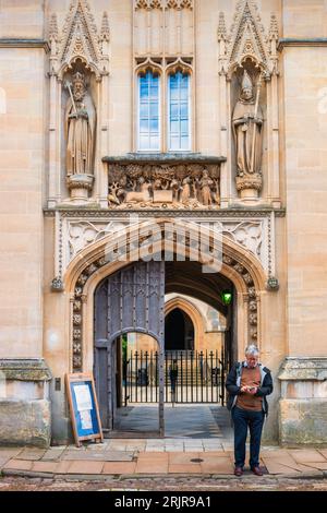 Man stands in front of Merton College in Oxford, England, UK Stock Photo