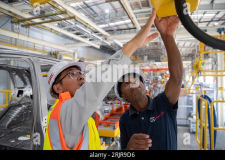 Pékin, Chine. 9 mai 2023. L'électricien sud-africain Bongani Nciwa (à droite) travaille avec son collègue chinois Fang long dans une usine du constructeur automobile chinois Beijing Automotive Industry Corporation dans la province du Cap oriental en Afrique du Sud, le 9 mai 2023. Crédit : Zhang Yudong/Xinhua/Alamy Live News Banque D'Images