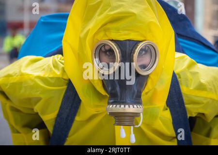 Une femme en costume jaune et un masque à gaz. Banque D'Images