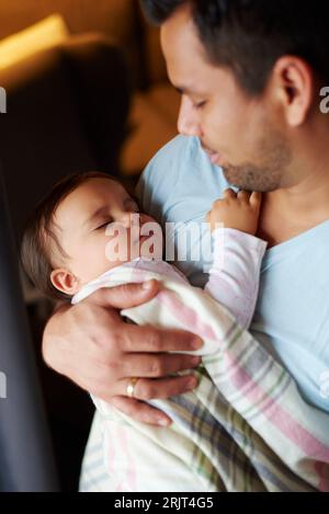 Père affectueux regardant une petite fille dormir dans ses bras Banque D'Images