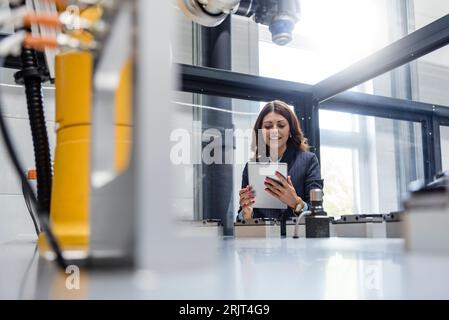 Femme d'affaires, travaillant dans une entreprise de haute technologie, using digital tablet Banque D'Images