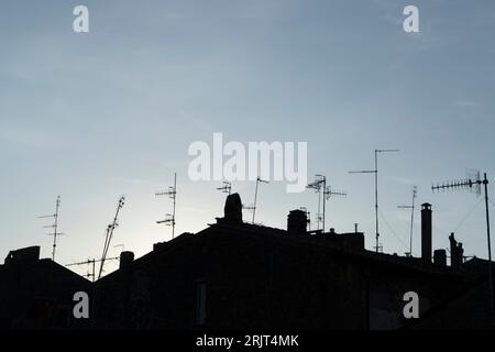 Une vue panoramique des antennes de télévision debout sur la silhouette des toits contre un ciel bleu Banque D'Images