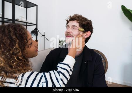 Fille donnant père un visage massgae avec un rouleau de jade Banque D'Images