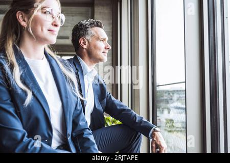 Smiling businessman and businesswoman in office Banque D'Images