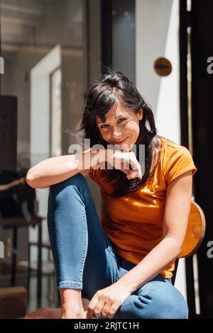 Heureuse femme mature assise sur une chaise Banque D'Images