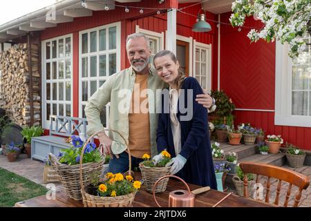 Couple heureux debout près des plantes dans la cour arrière Banque D'Images