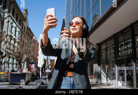 Femme souriante prenant le selfie par smartphone Banque D'Images