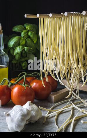 Pâtes fraîches de linguine séchant sur une grille en bois. Format portrait, gros plan. Banque D'Images