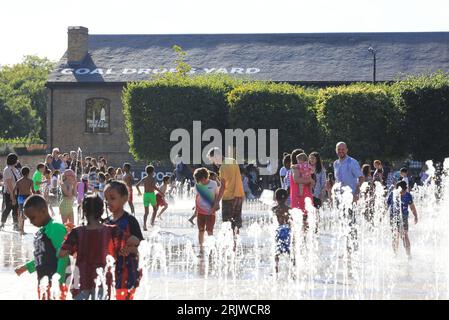 Londres, Royaume-Uni, 23 août 2023. Les familles ont profité du temps chaud et ensoleillé en jouant dans les fontaines de Granary Square, Kings Cross, au nord de Londres. Les températures ont finalement grimpé en flèche après un été misérable que les vacances scolaires approchent de la fin Crédit : Monica Wells/Alamy Live News Banque D'Images