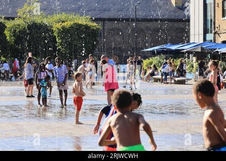 Londres, Royaume-Uni, 23 août 2023. Les familles ont profité du temps chaud et ensoleillé en jouant dans les fontaines de Granary Square, Kings Cross, au nord de Londres. Les températures ont finalement grimpé en flèche après un été misérable que les vacances scolaires approchent de la fin Crédit : Monica Wells/Alamy Live News Banque D'Images