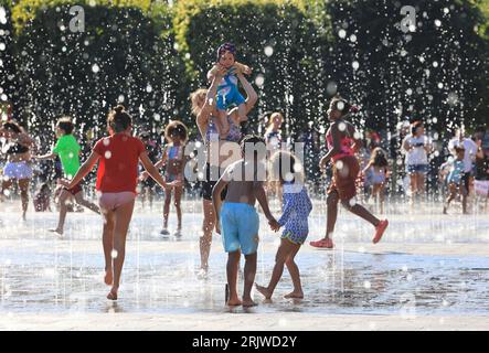 Londres, Royaume-Uni, 23 août 2023. Les familles ont profité du temps chaud et ensoleillé en jouant dans les fontaines de Granary Square, Kings Cross, au nord de Londres. Les températures ont finalement grimpé en flèche après un été misérable que les vacances scolaires approchent de la fin Crédit : Monica Wells/Alamy Live News Banque D'Images